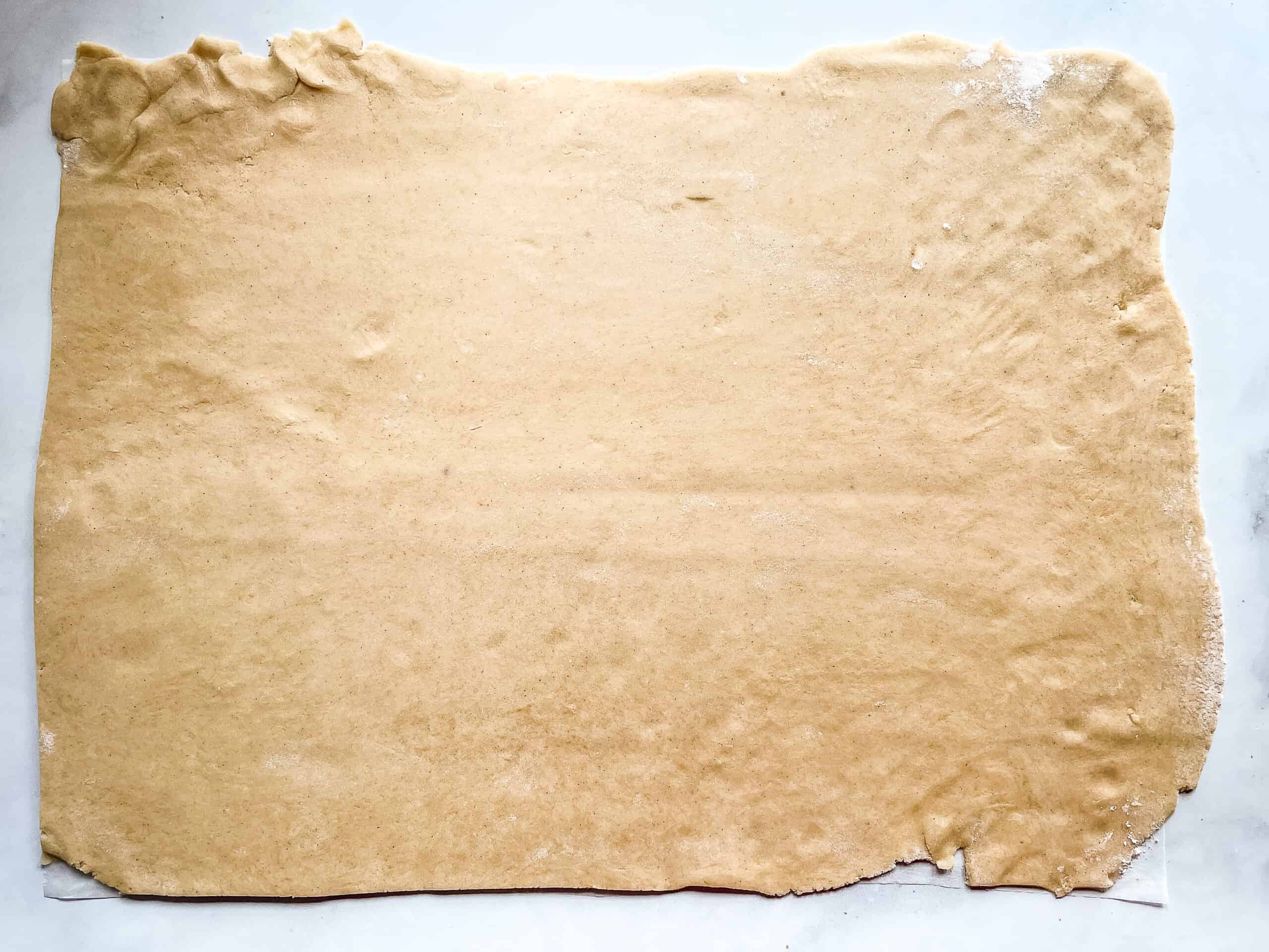 Gluten-free graham cracker dough rolled out into a large sheet.