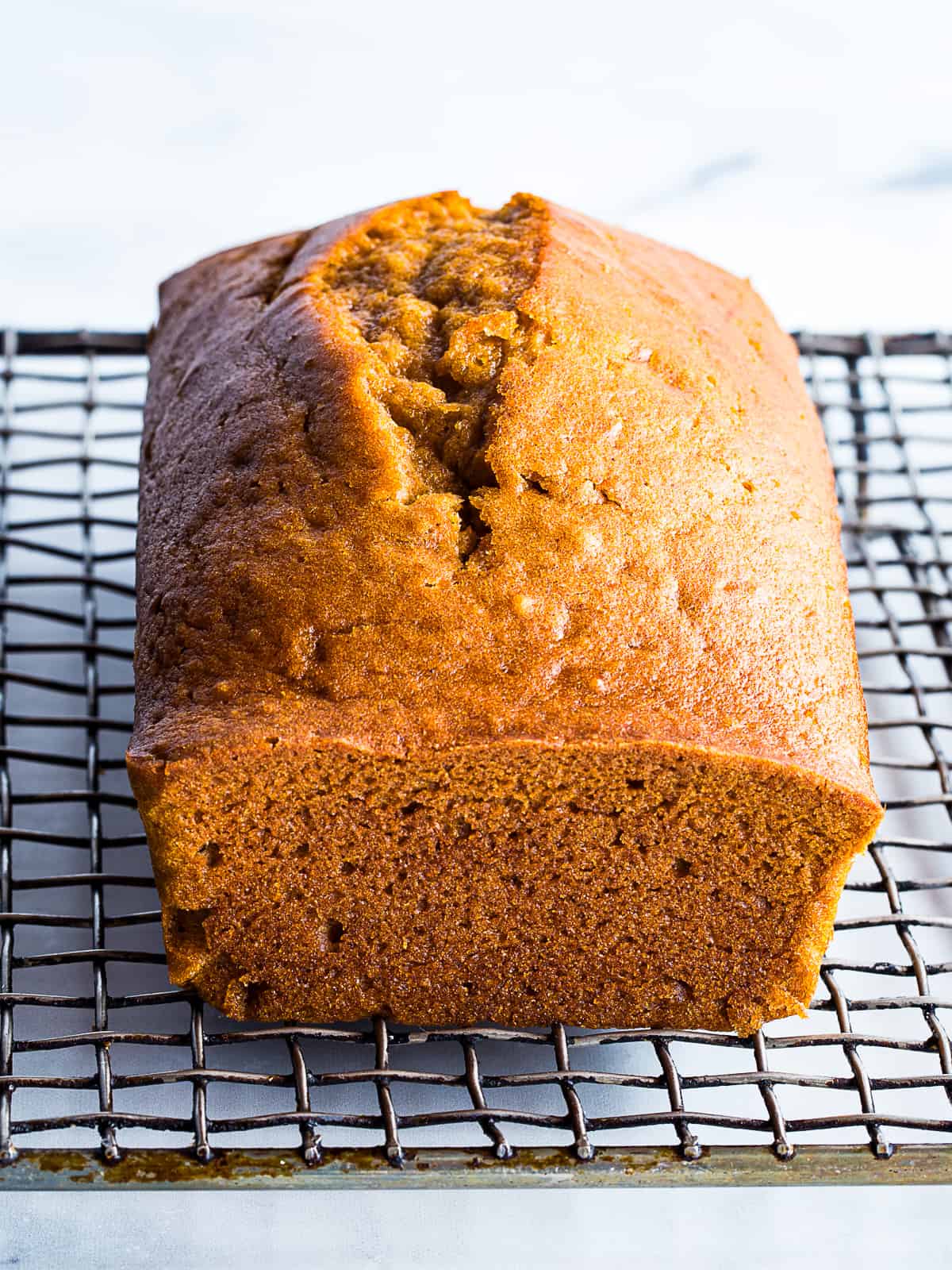 Gluten-free pumpkin bread cooling on a rack.