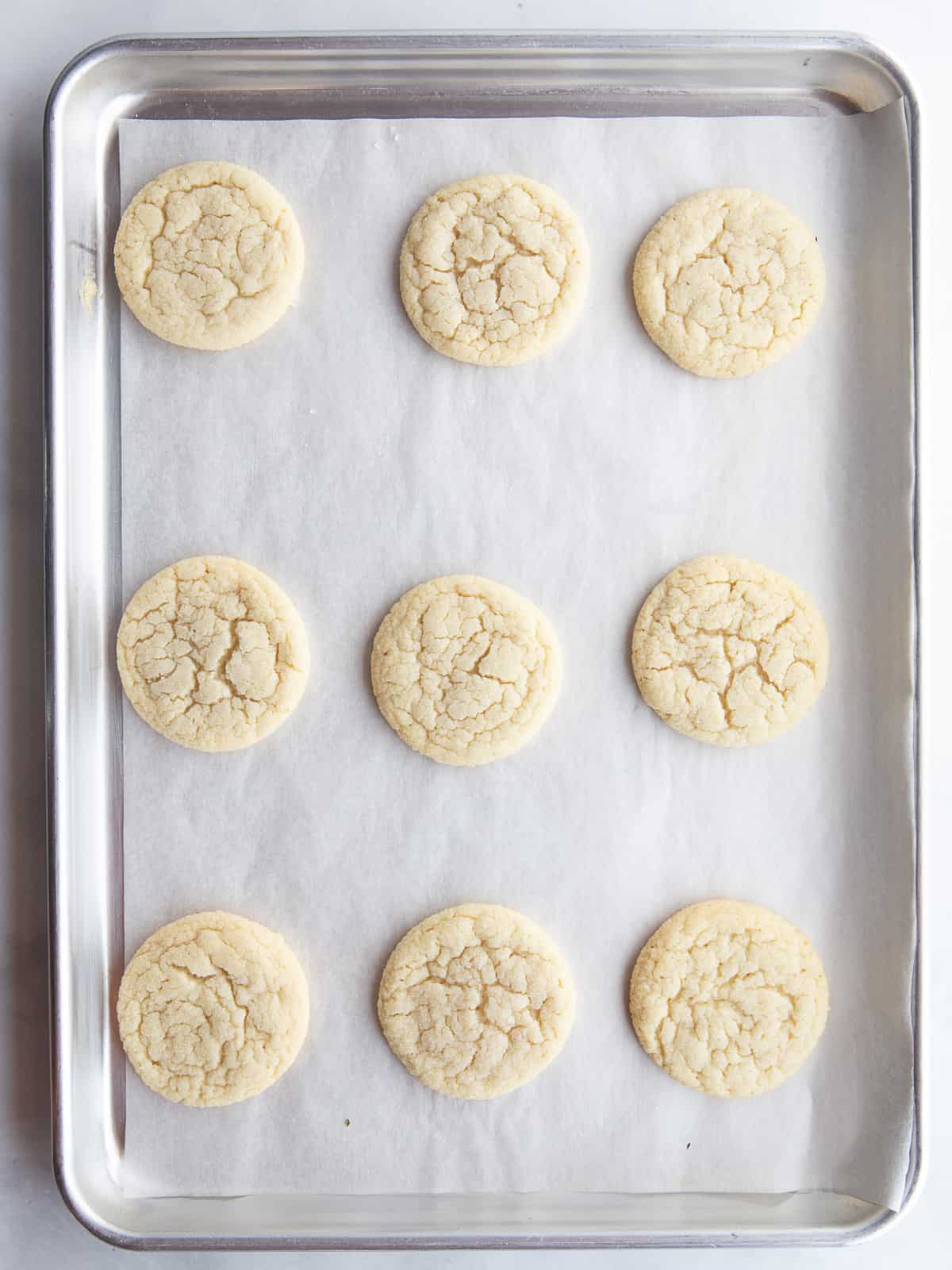 Baked gluten-free sugar cookies on a baking sheet.