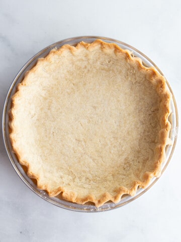 Empty baked gluten-free pie crust cooling in a pan.