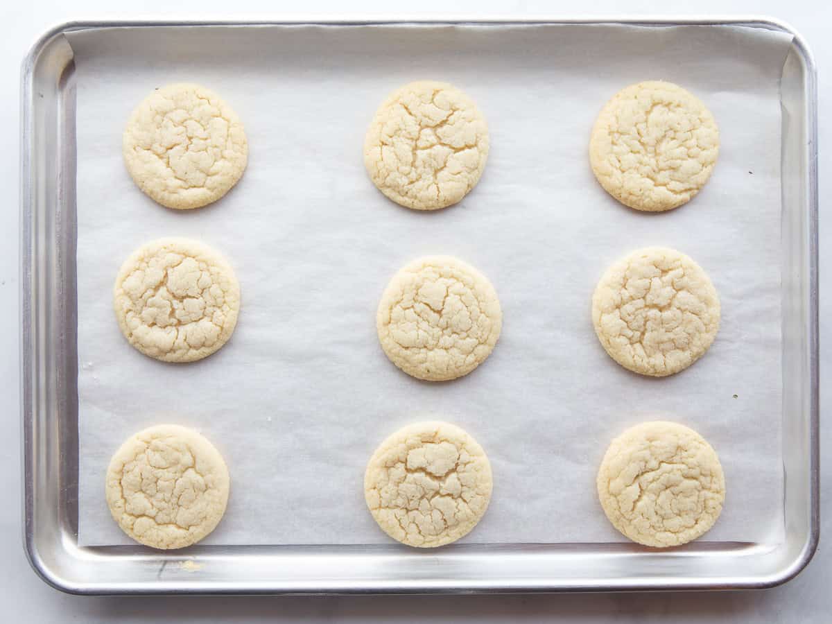 Baked gluten-free sugar cookies on a baking sheet.