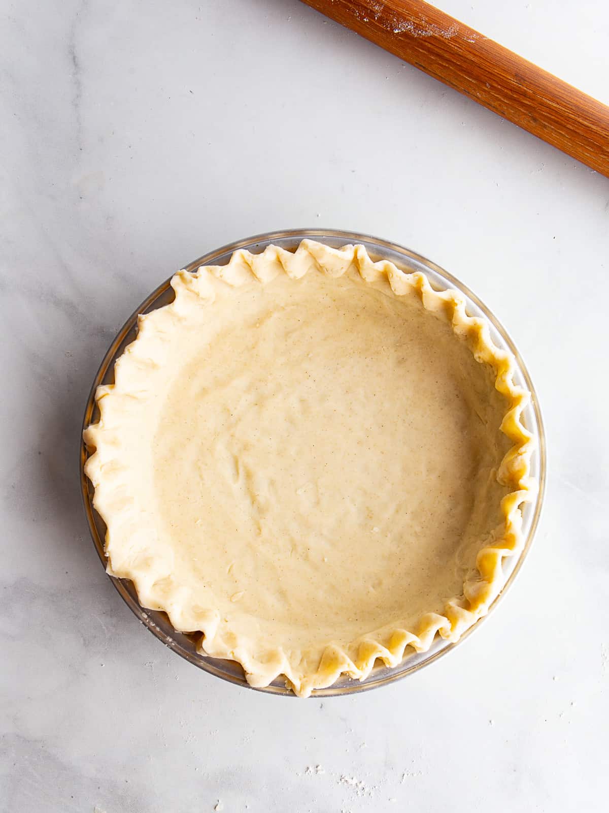 Unbaked gluten-free pie crust in a pan.