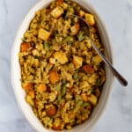 Gluten-free cornbread stuffing in an oval bowl with serving spoon.