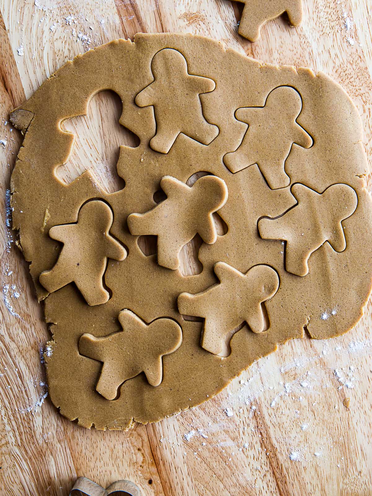 Gluten free gingerbread dough cut into gingerbread men shapes.