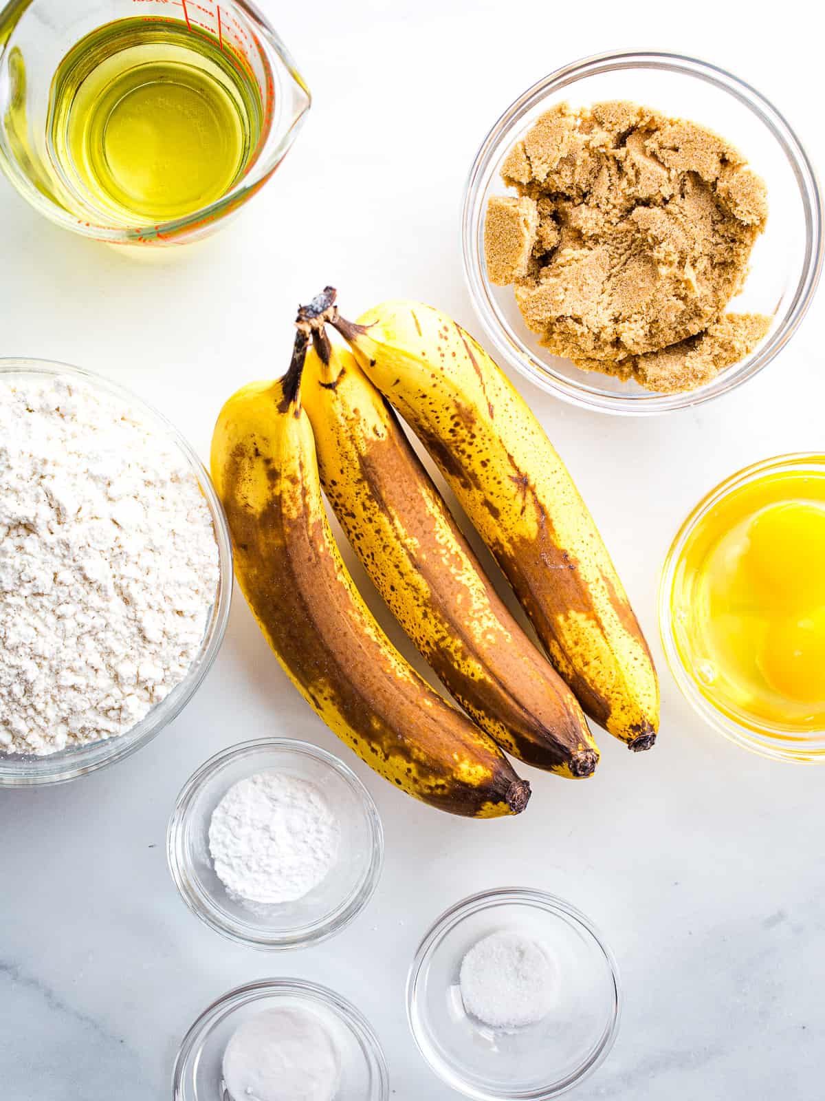 Gluten-free banana muffin recipe ingredients on a counter.