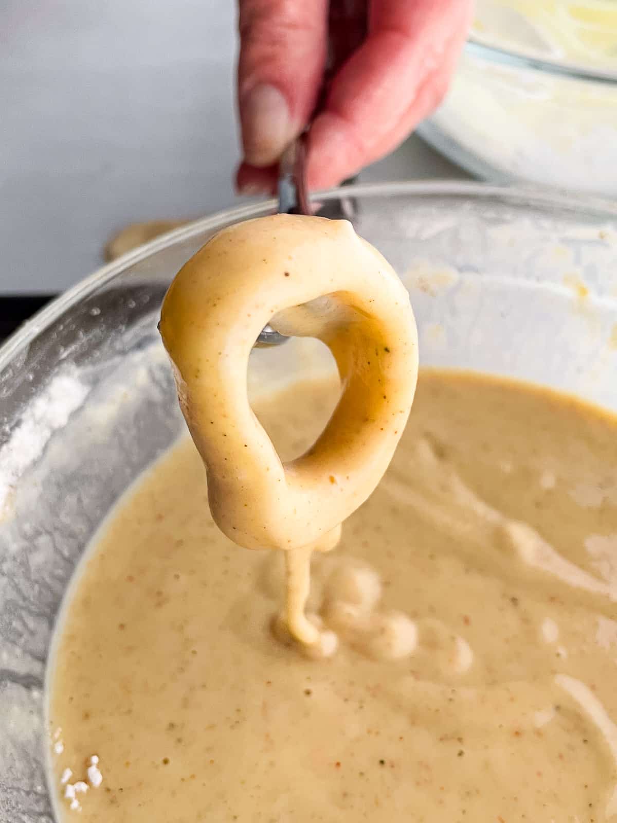 Letting gluten-free batter drip off an onion ring.