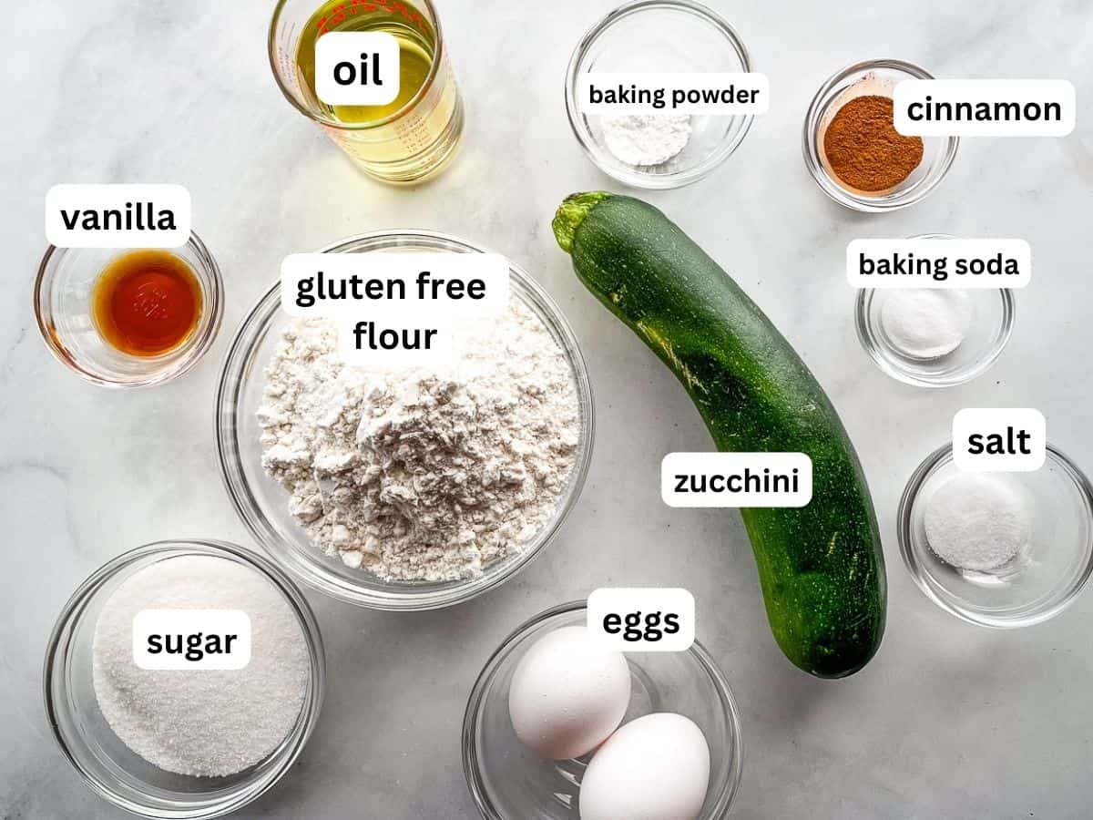 Ingredients for gluten-free zucchini muffins measured in individual bowls on the counter.