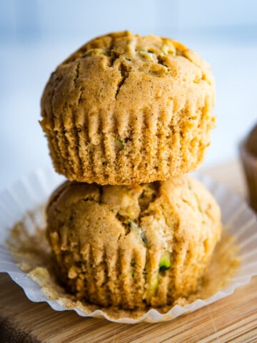 Two gluten-free zucchini muffins stacked on top of each other.