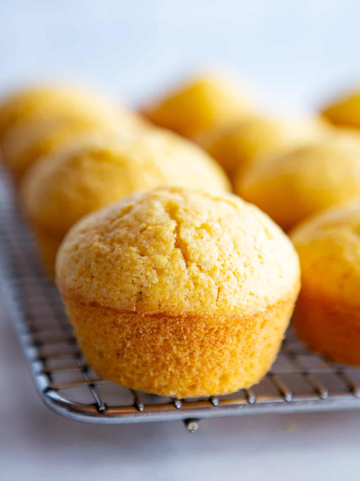 Gluten-free corn muffins cooling on a rack.
