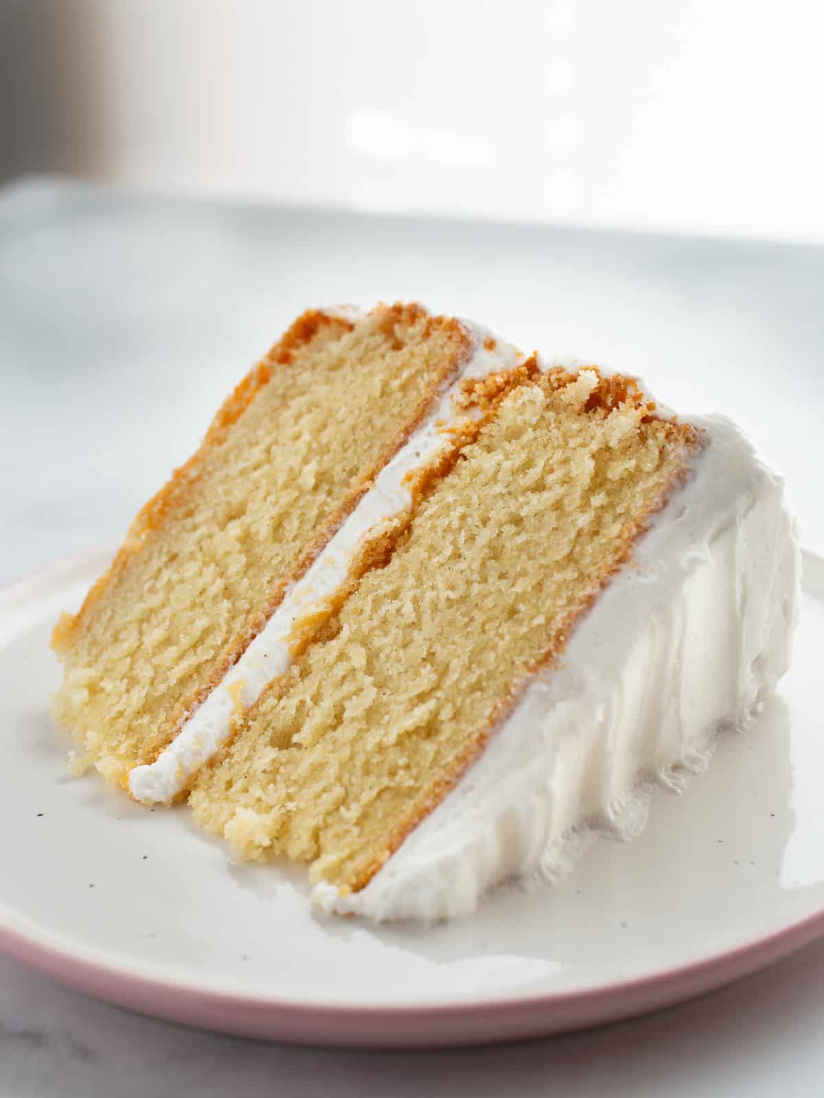A slice of gluten-free vanilla cake on a plate.