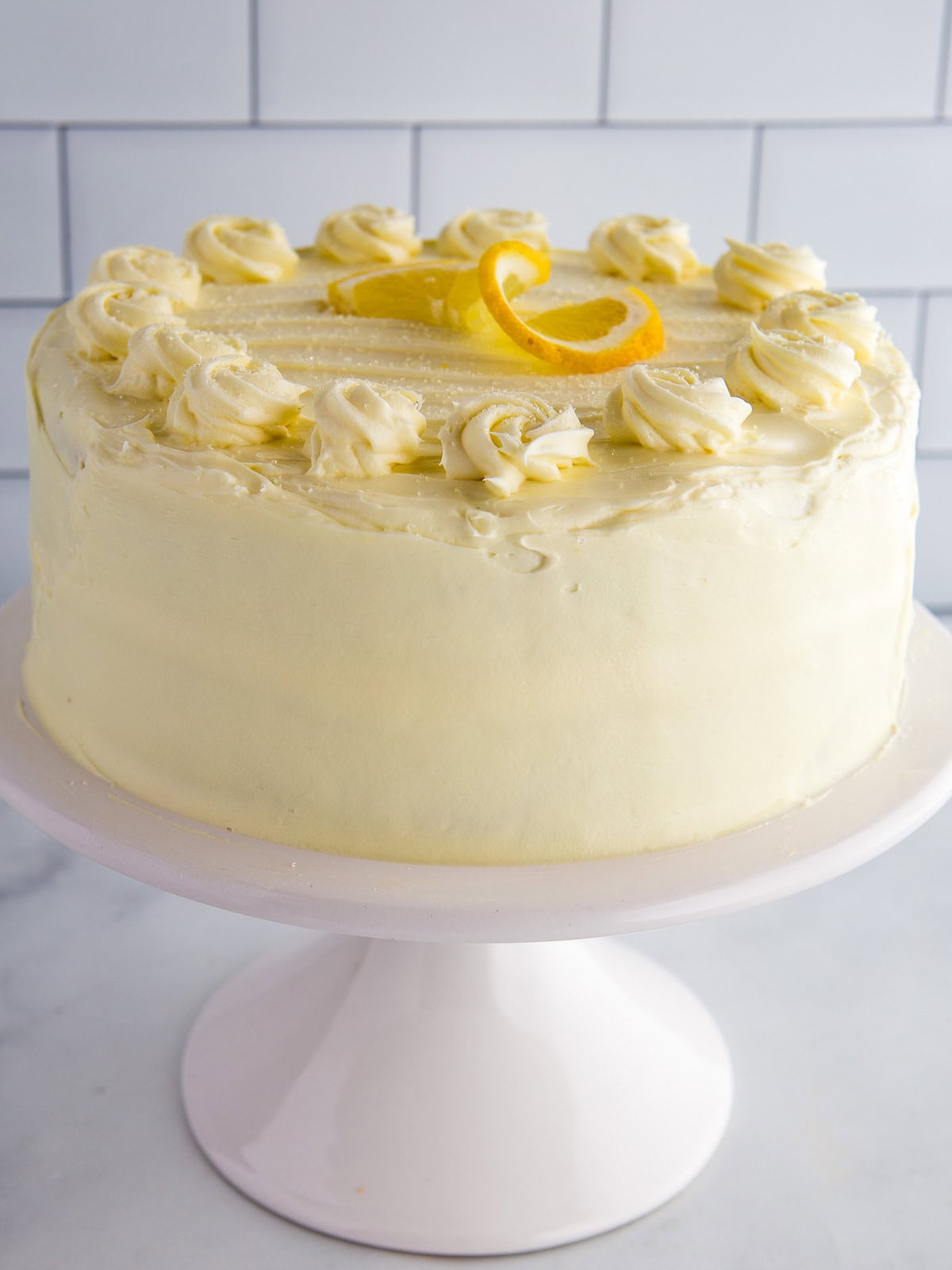A gluten-free lemon cake on a cake stand.