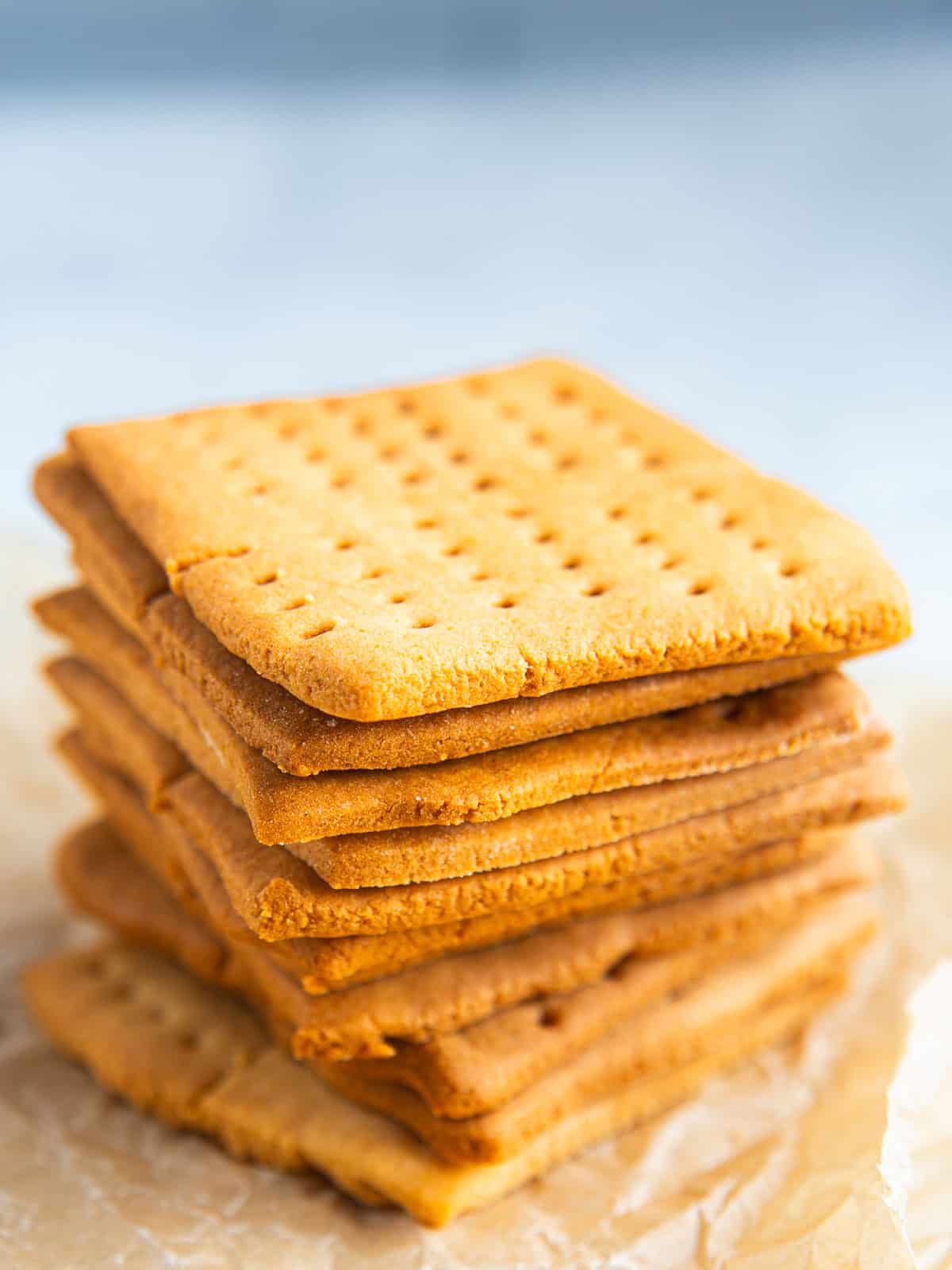 A stack of gluten-free graham crackers sitting on brown parchment paper.