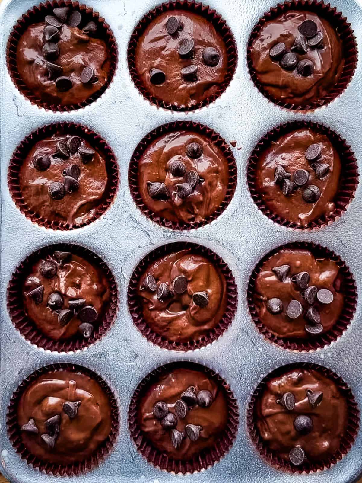 Gluten-free chocolate muffin batter in a muffin pan.