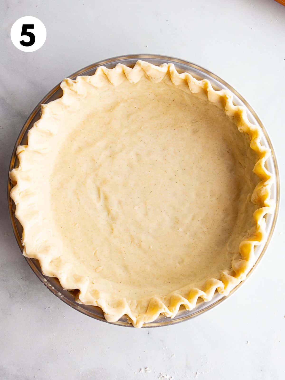 Gluten free pie dough in pan with crimped edges.