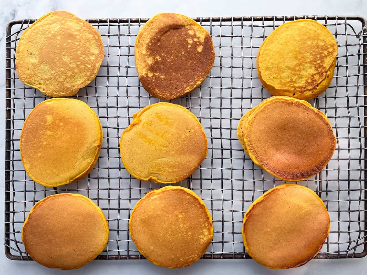 Gluten-free pumpkin pancakes cooling on a rack.